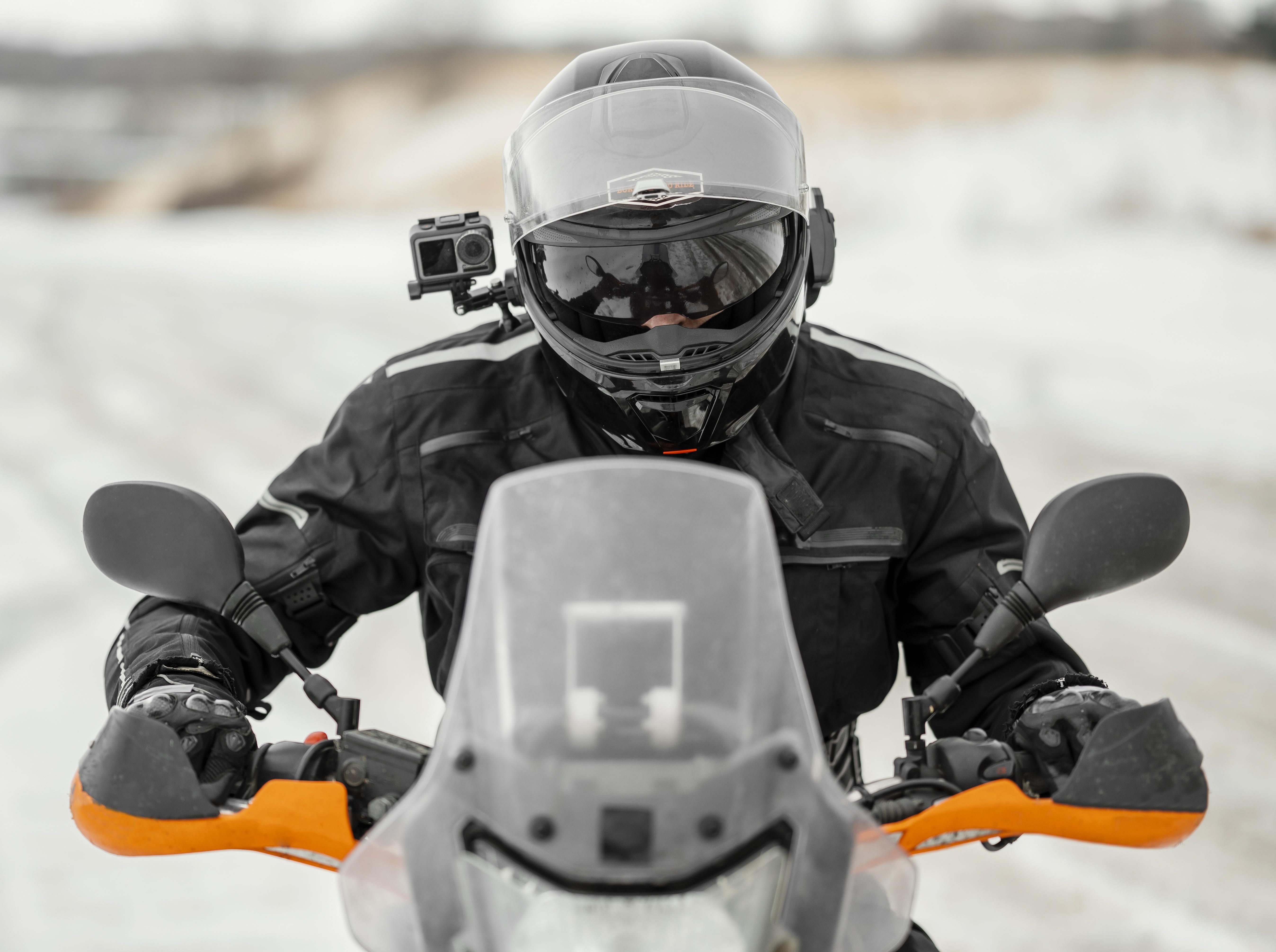 Motociclista con equipamiento completo de proteccion en dia de invierno